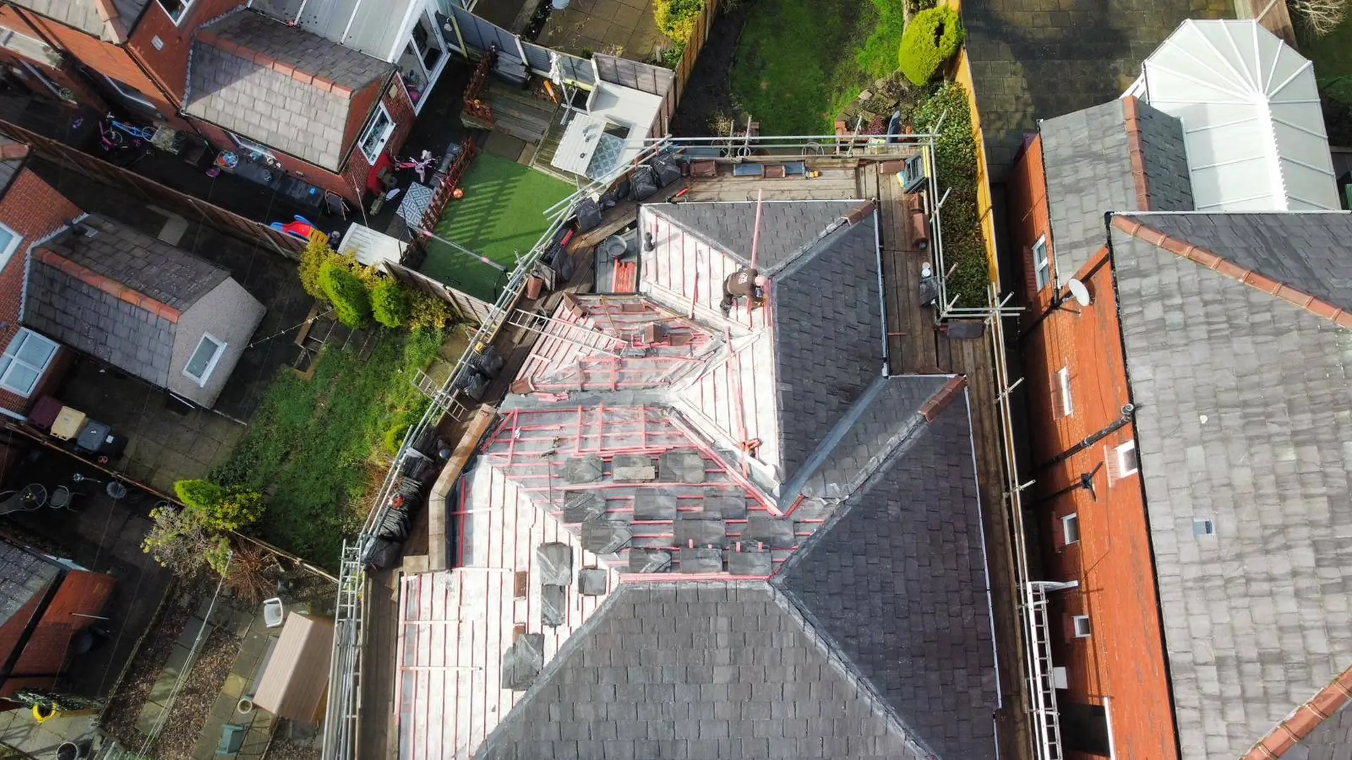 Aerial view of a J.E.M Roofing slate roof replacement in progress with scaffolding